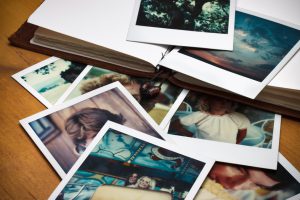A pile of old pictures and a journal to document memories of past times.